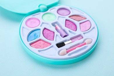 Photo of Decorative cosmetics for kids. Eye shadow palette on light blue background, closeup