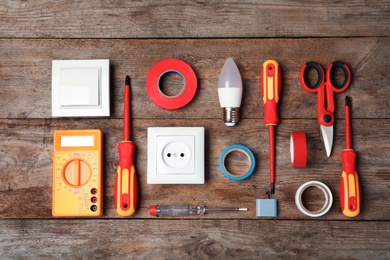 Flat lay composition with electrician's tools on wooden background