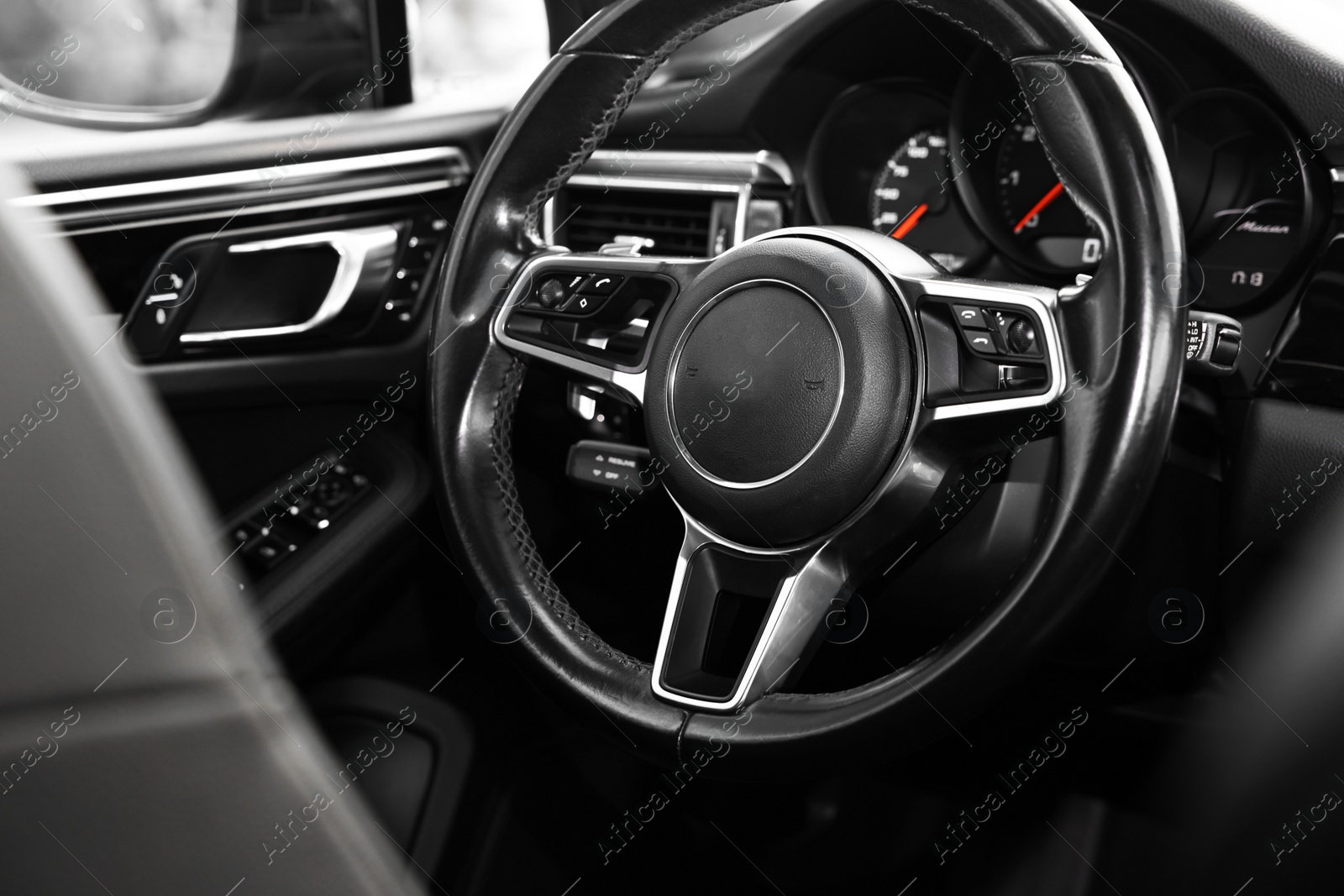 Photo of Steering wheel inside of modern black car, closeup