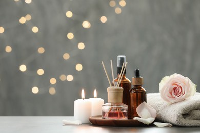 Photo of Composition with different spa products and rose flower on light table, space for text