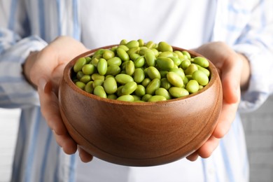 Photo of Woman holding bowl of edamame beans, closeup