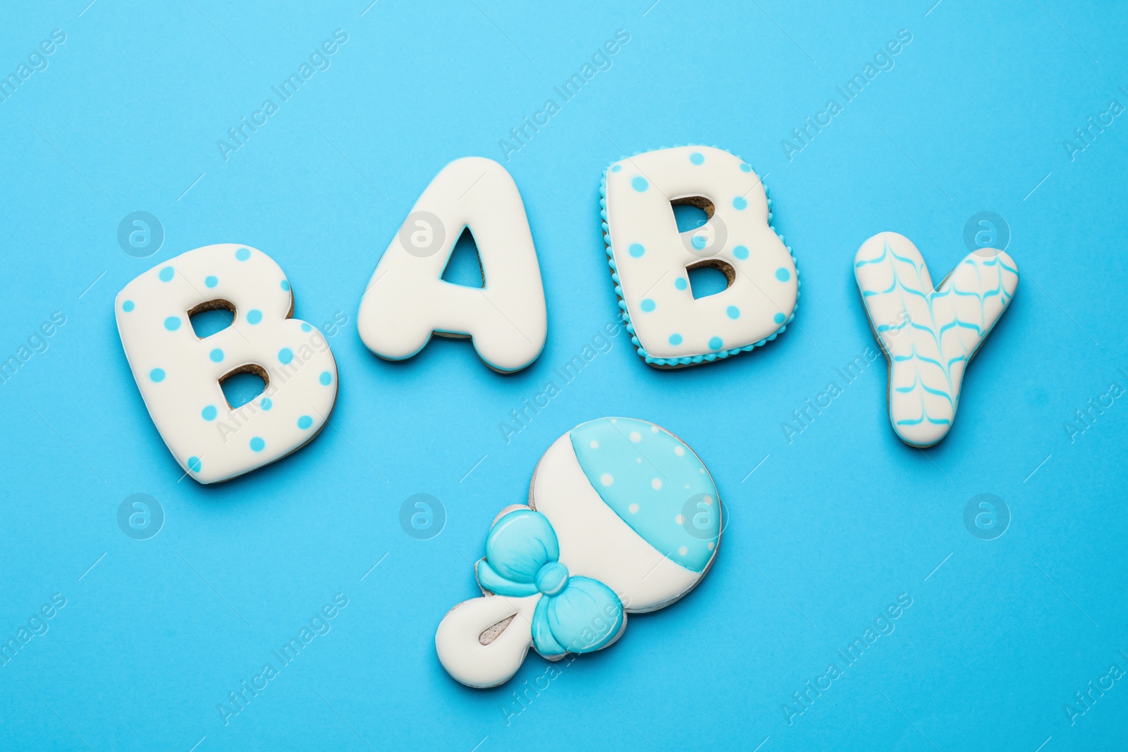 Photo of Word BABY made of tasty cookies on light blue background, flat lay
