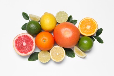 Photo of Different cut and whole citrus fruits on white table, flat lay