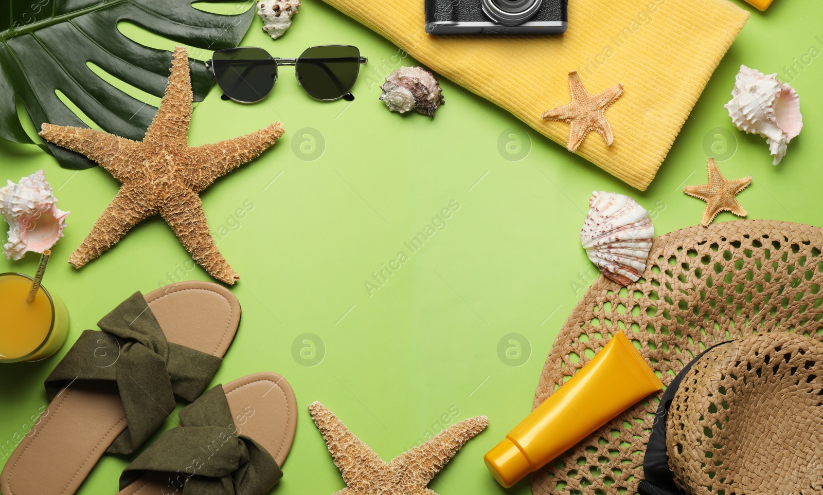 Photo of Frame of different beach objects on green background, flat lay. Space for text