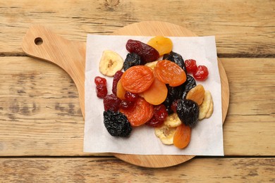 Photo of Mix of delicious dried fruits on wooden table, top view