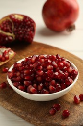 Photo of Ripe juicy pomegranate grains on white table, closeup