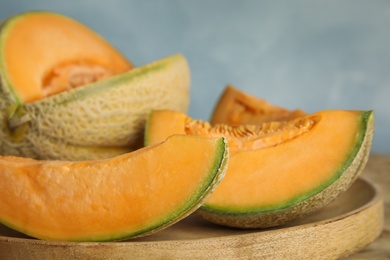 Photo of Tasty fresh cut melons on wooden tray, closeup