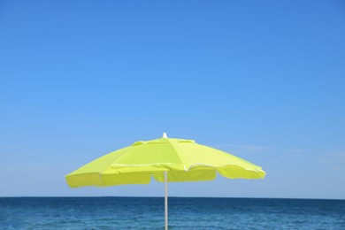 Photo of Yellow beach umbrella near sea on sunny day