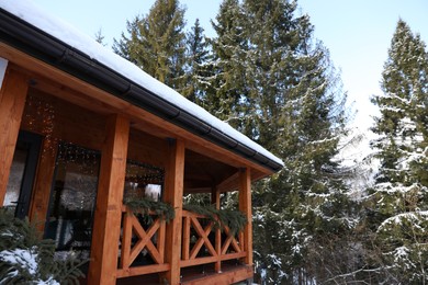 Photo of Wooden gazebo near snowy forest on winter day