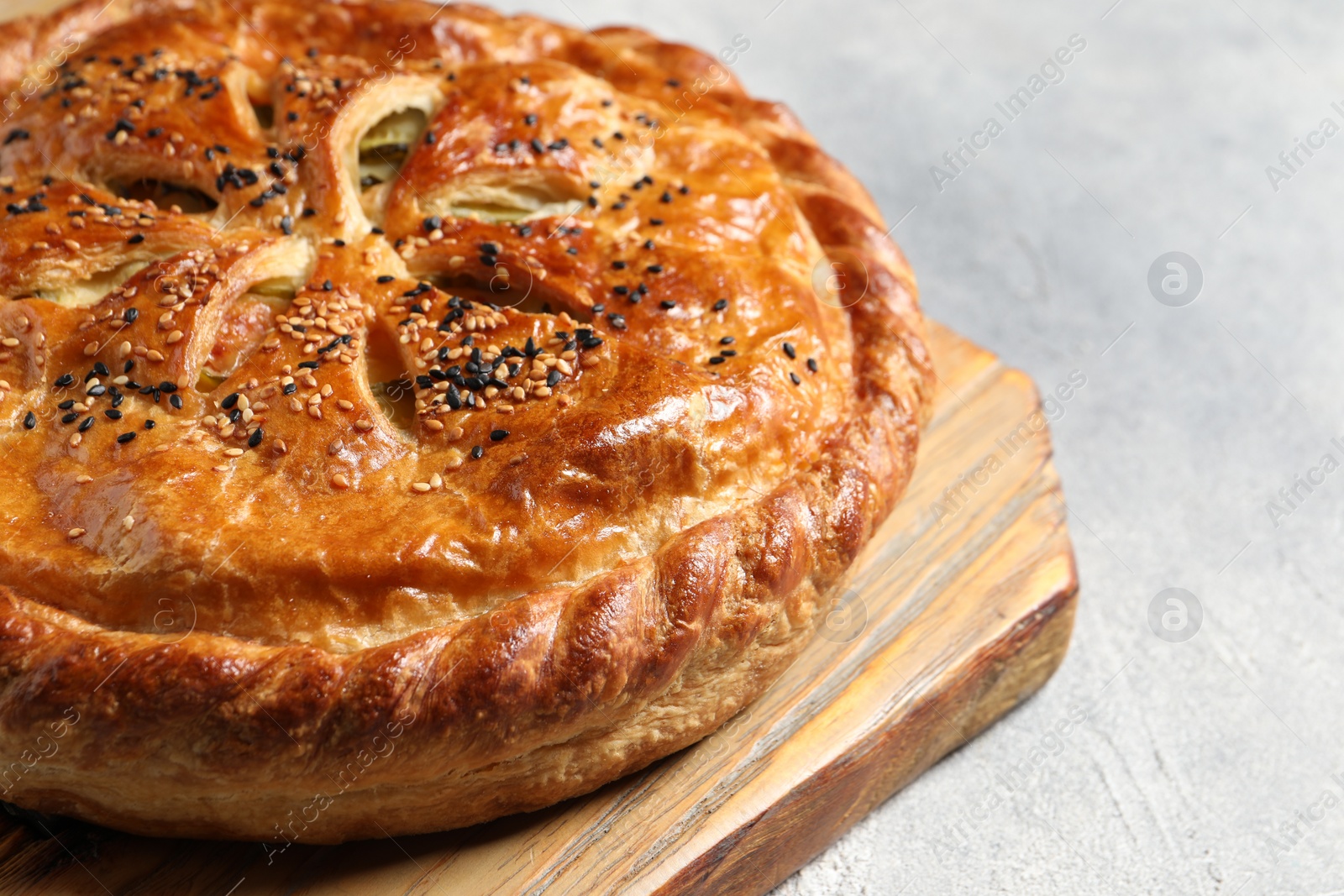 Photo of Tasty homemade pie with filling on light grey table, closeup