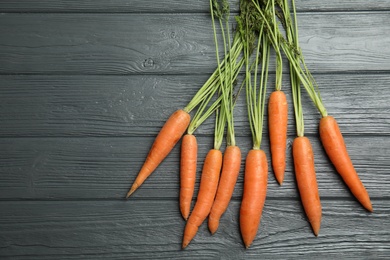 Photo of Ripe carrots on wooden background, top view