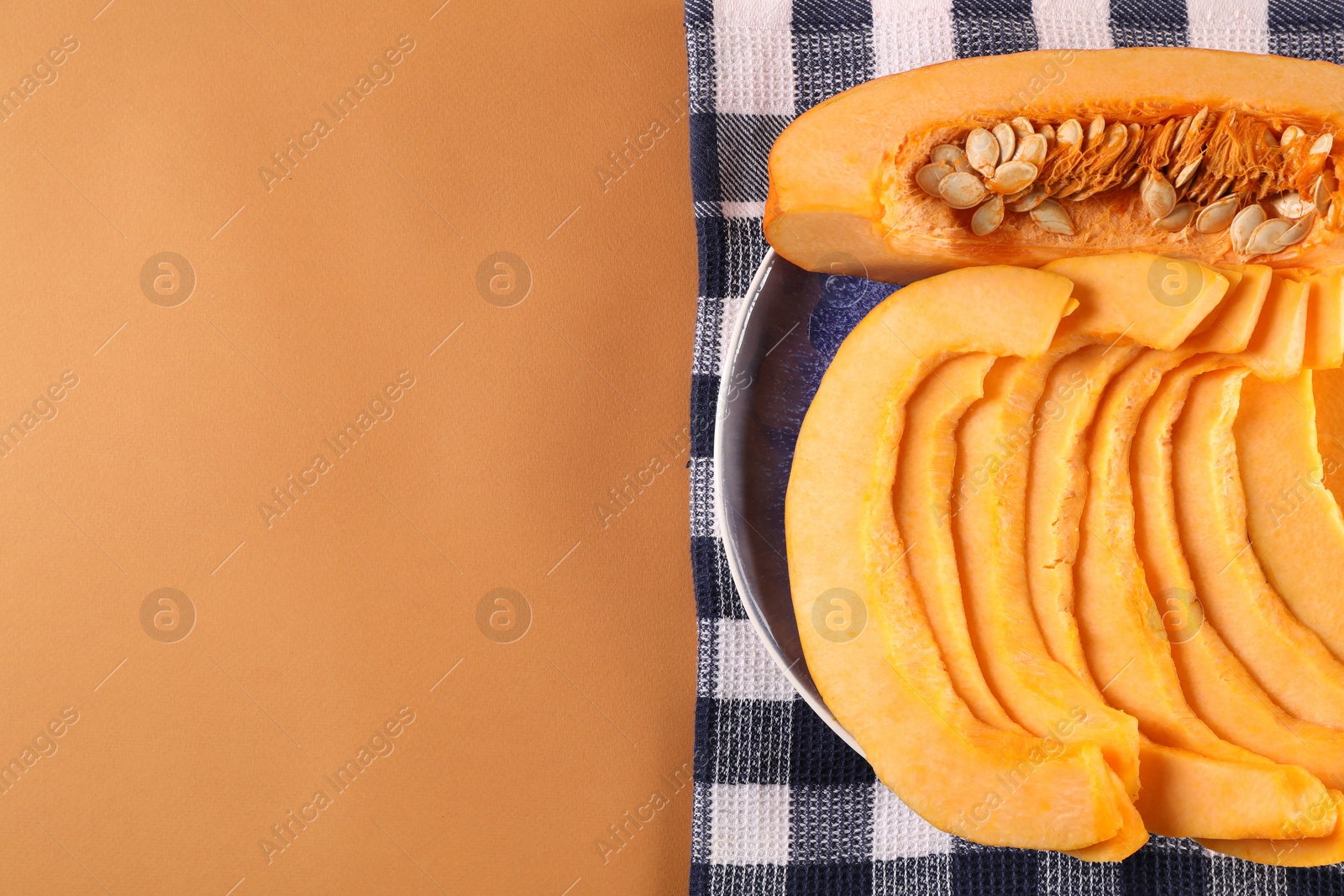 Photo of Slices of fresh ripe pumpkin on orange background, top view. Space for text