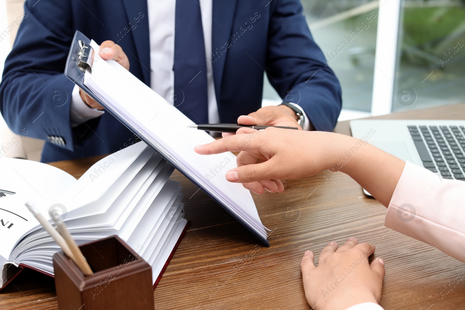 Photo of Male lawyer working with client at table, closeup