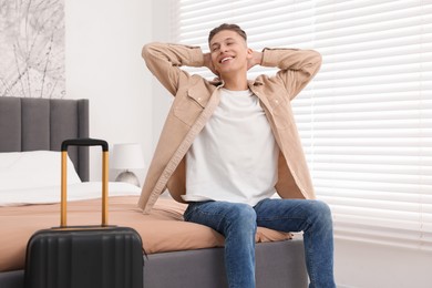 Smiling guest stretching in stylish hotel room