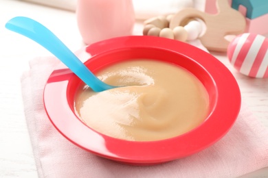 Photo of Bowl of healthy baby food on table, closeup