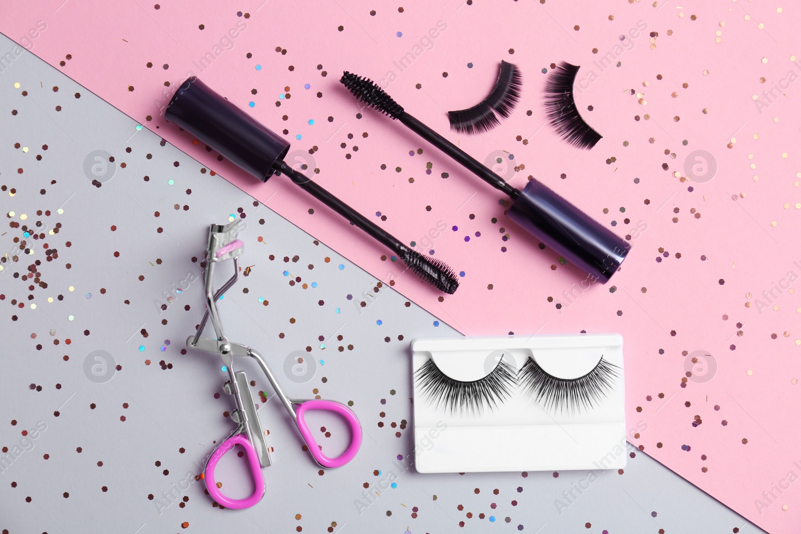 Photo of Flat lay composition with false eyelashes and cosmetic tools on color background