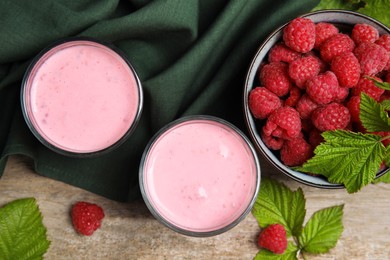 Tasty raspberry smoothie and fresh berries on wooden table, flat lay