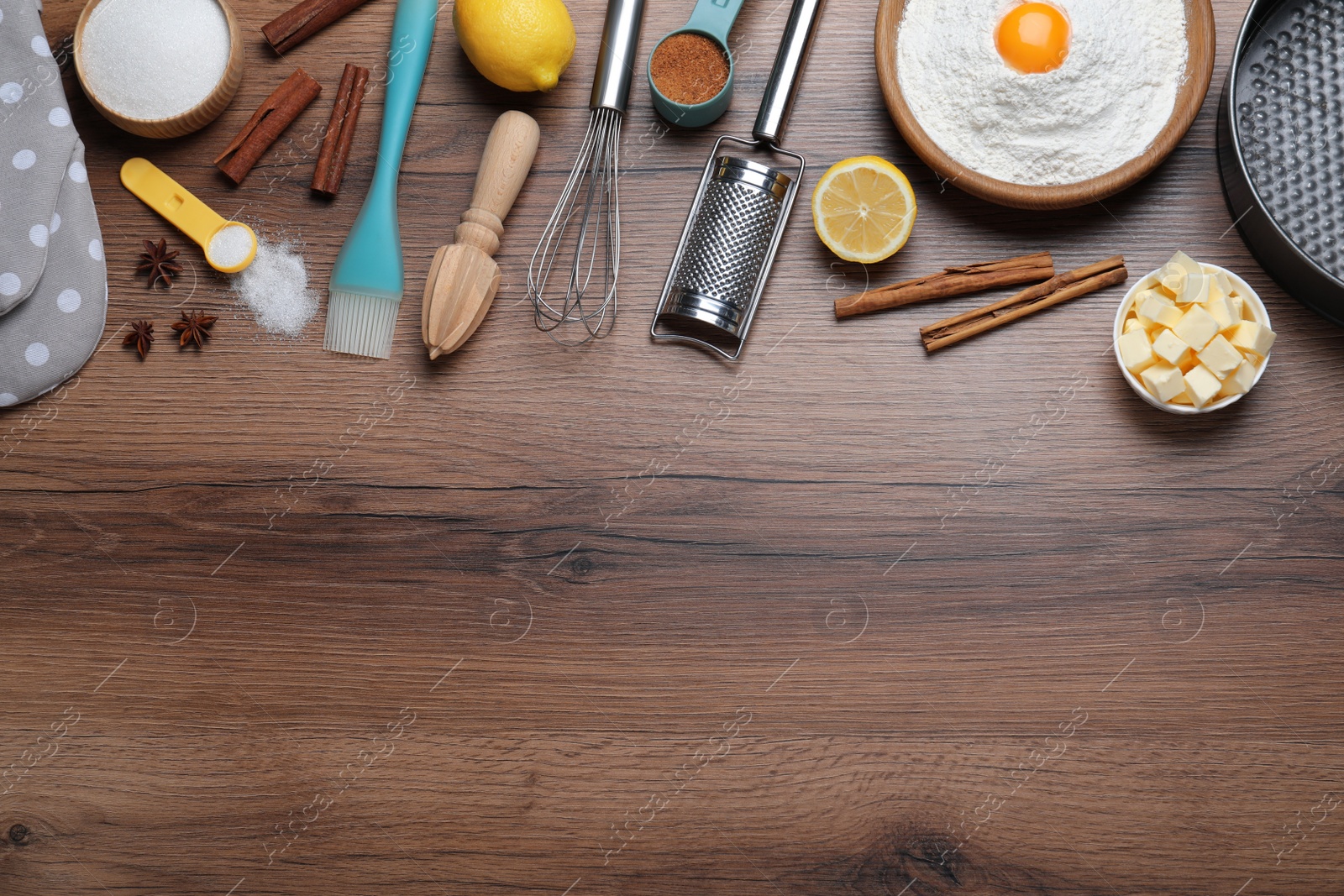 Photo of Cooking utensils and ingredients on wooden table, flat lay. Space for text