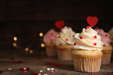 Tasty sweet cupcakes on wooden table, space for text. Happy Valentine's Day
