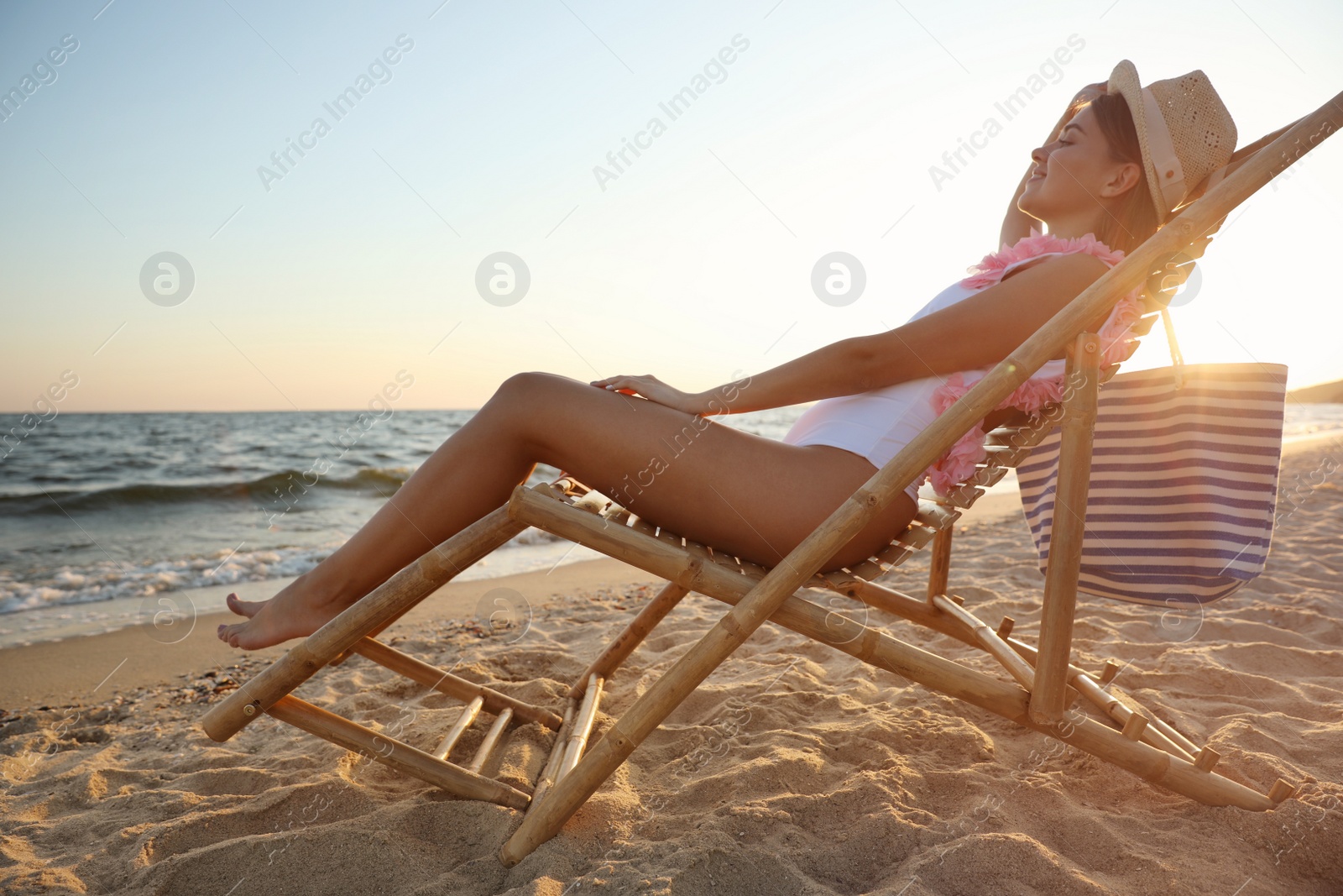 Photo of Young woman relaxing in deck chair on beach