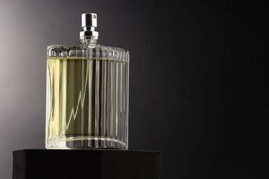 Photo of Luxury men`s perfume in bottle against dark background, space for text