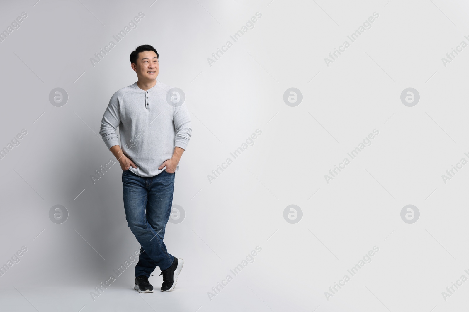 Photo of Full length portrait of happy man on light background. Space for text