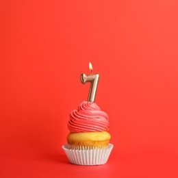 Photo of Birthday cupcake with number seven candle on red background
