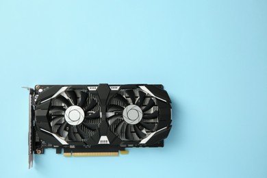 Photo of Computer graphics card on light blue background, top view. Space for text