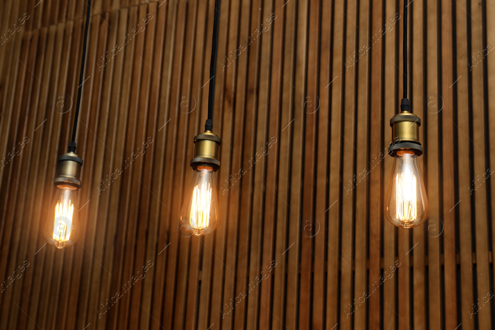 Photo of Pendant lamps with light bulbs on wooden background