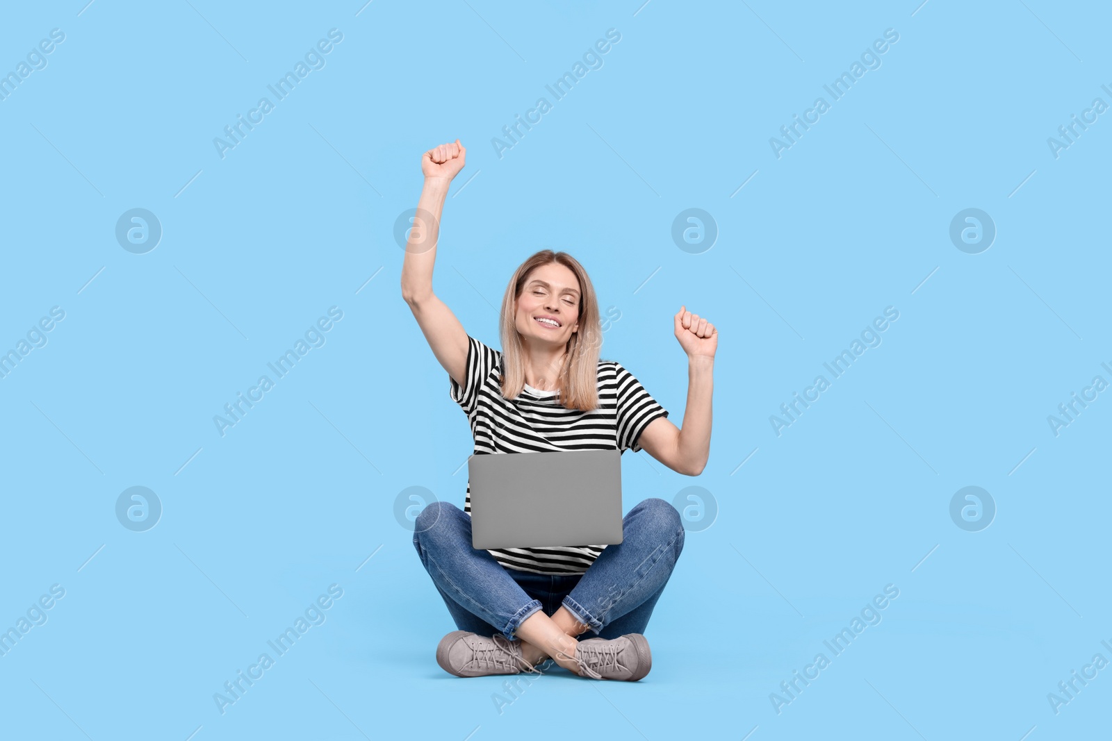 Photo of Emotional woman with laptop on light blue background