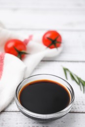 Photo of Bowl with balsamic vinegar and tomatoes on white wooden table. Space for text