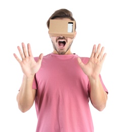 Photo of Young man using cardboard virtual reality headset, isolated on white