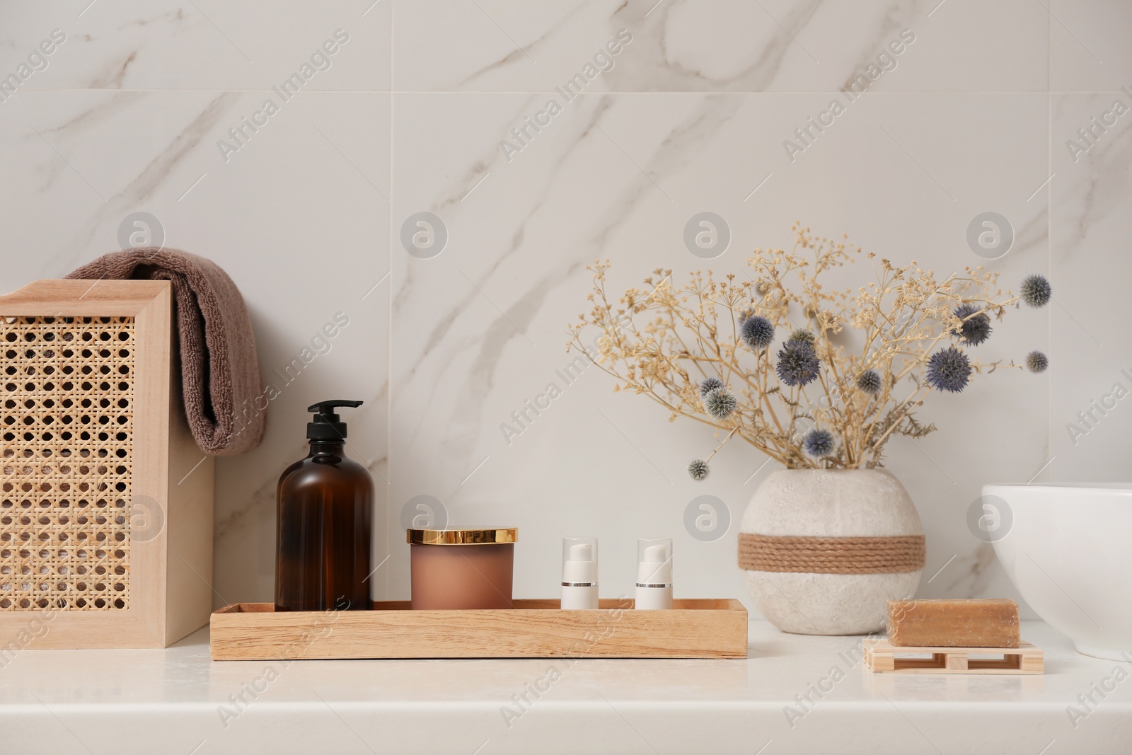 Photo of Personal hygiene products and toiletries on table near white wall in bathroom