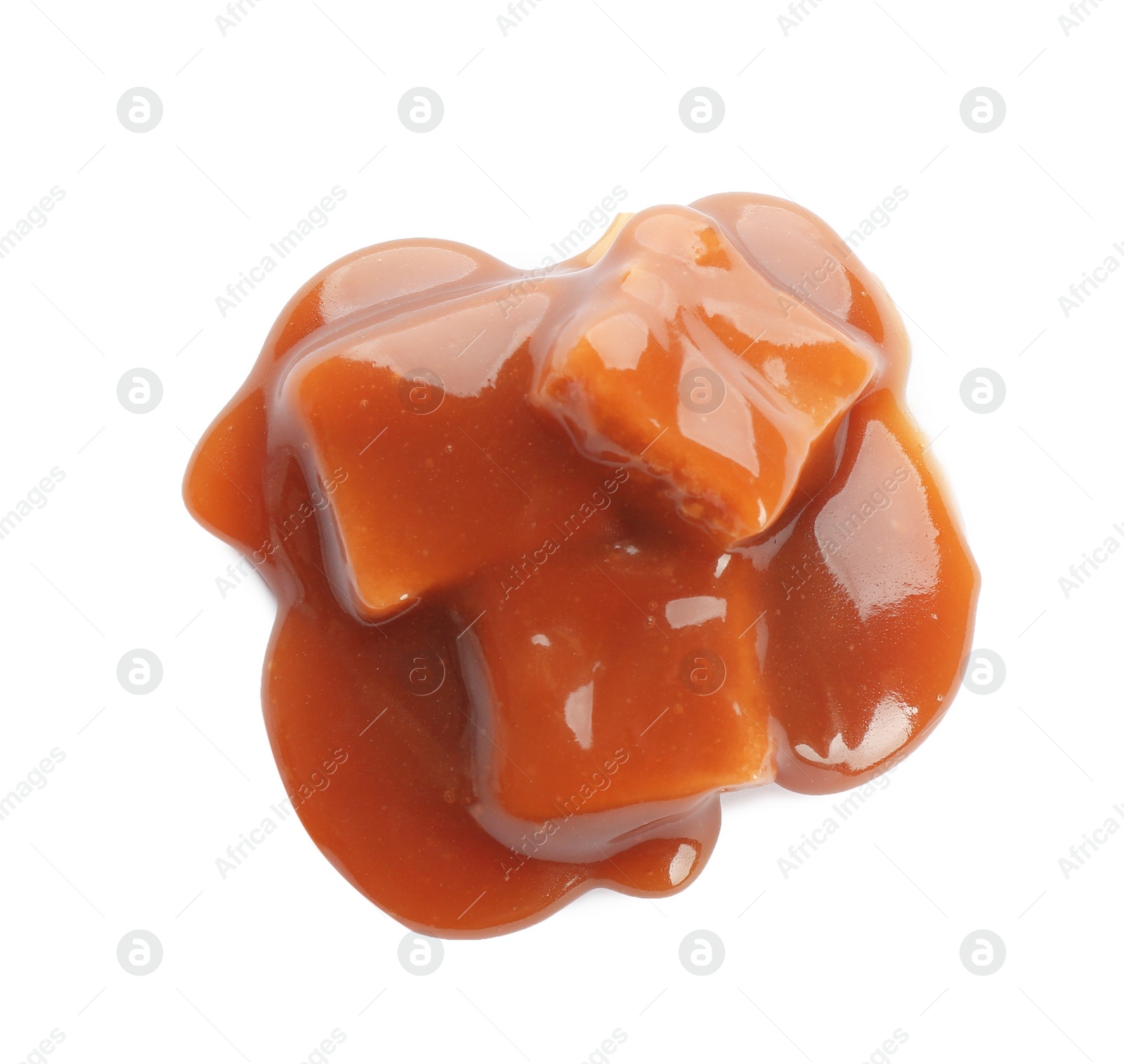 Photo of Caramel candies under tasty sauce isolated on white, top view