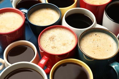 Photo of Many cups of different coffee drinks on blue table