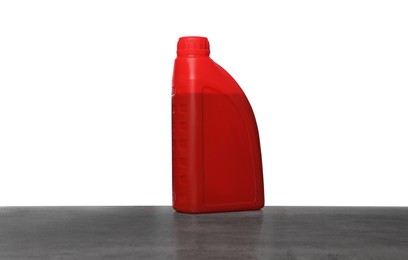 Photo of Motor oil in red container on grey table against white background