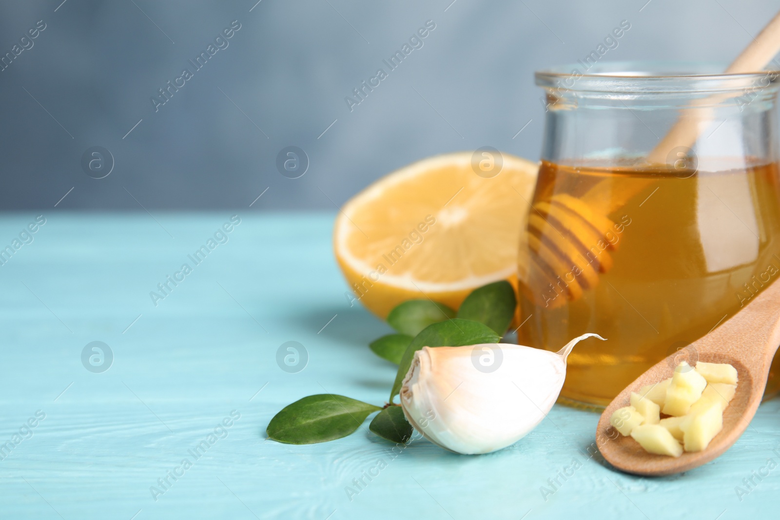 Photo of Composition with garlic and other cold remedies on blue wooden table. Space for text