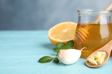 Photo of Composition with garlic and other cold remedies on blue wooden table. Space for text