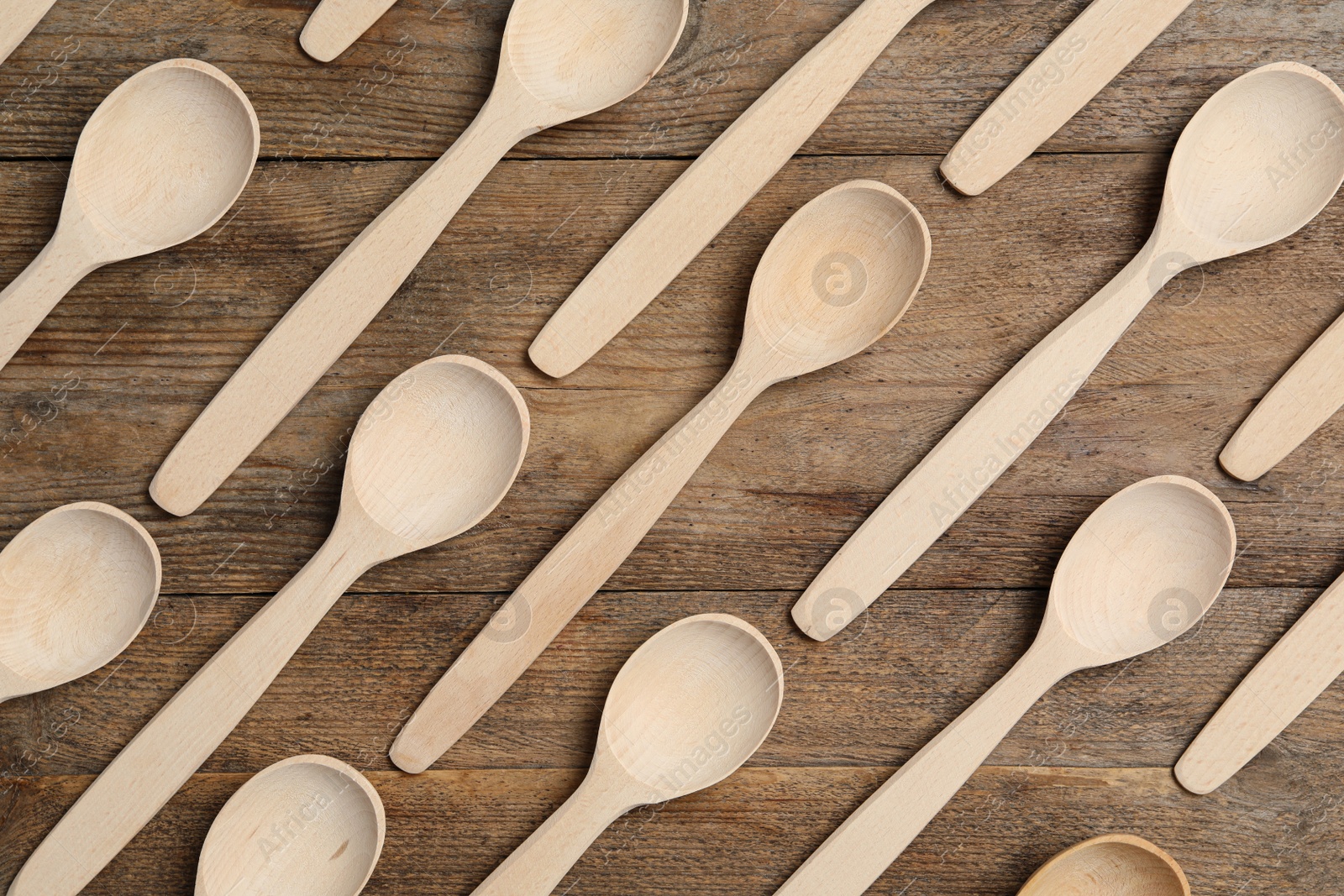 Photo of Many spoons on wooden table, flat lay. Cooking utensils