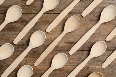 Many spoons on wooden table, flat lay. Cooking utensils