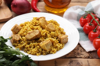 Photo of Delicious rice with chicken served on wooden table, closeup