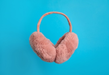 Photo of Stylish winter earmuffs on light blue background