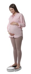 Pregnant woman standing on scales against white background