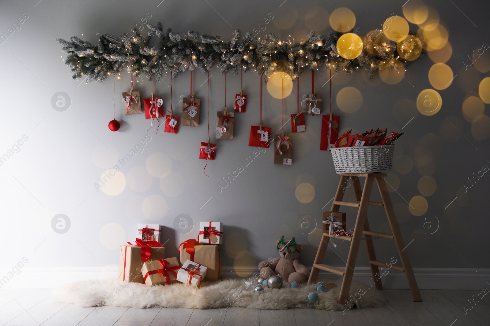 Image of Christmas advent calendar hanging on wall above gift boxes. Bokeh effect