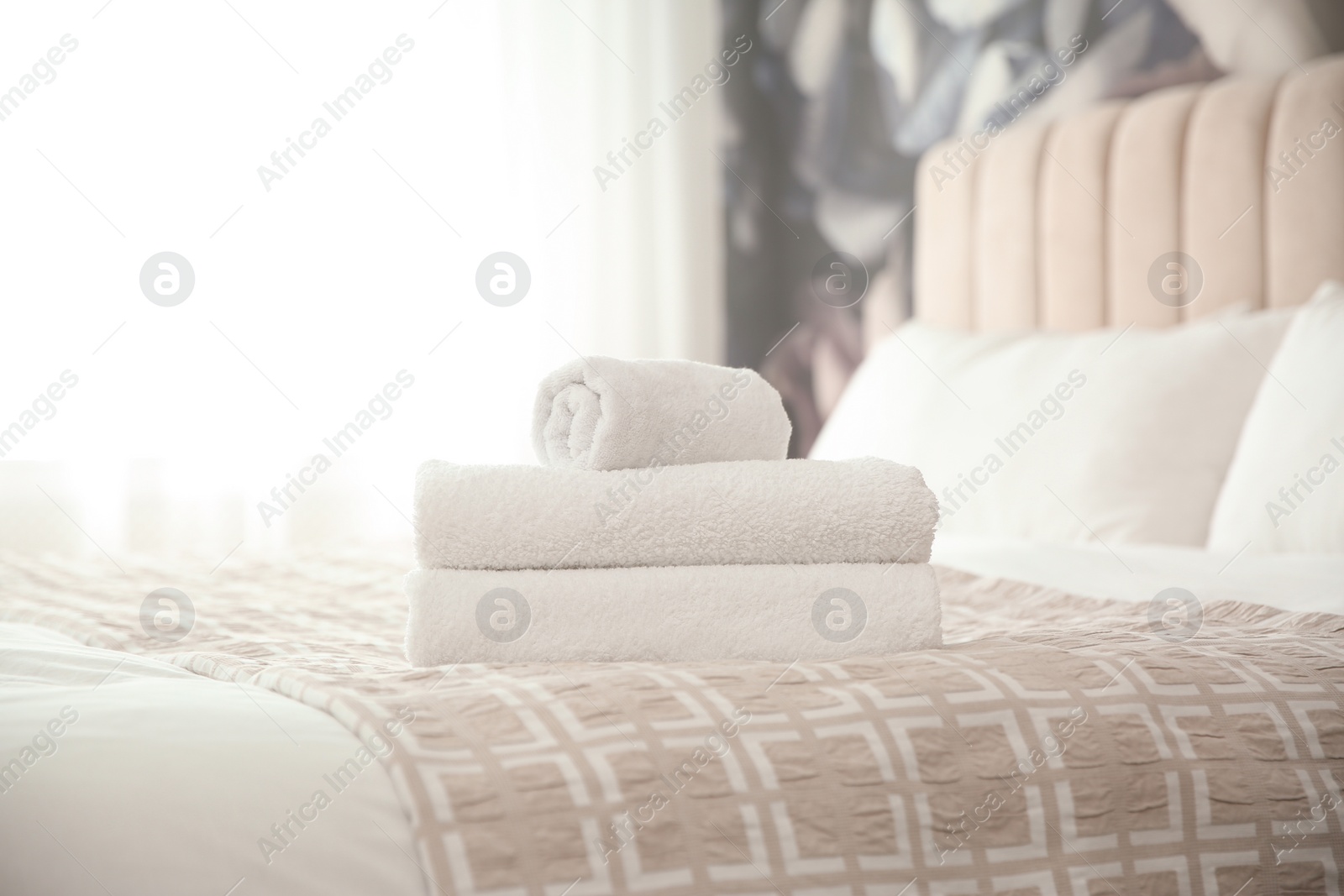 Photo of Clean white towels on bed at home