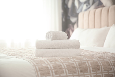 Clean white towels on bed at home