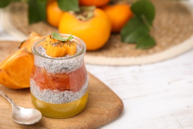 Photo of Delicious dessert with persimmon and chia seeds on table. Space for text