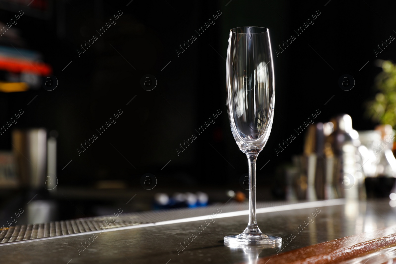 Photo of Empty clean champagne glass on counter in bar. Space for text