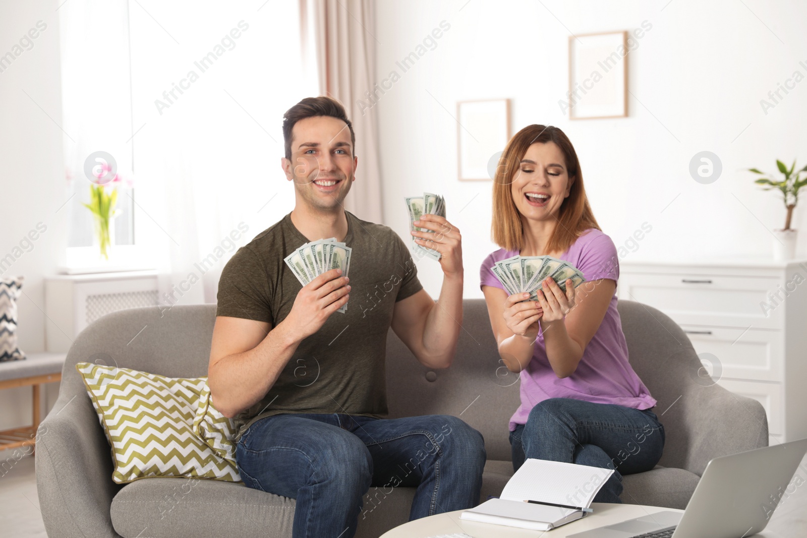 Photo of Couple with money on sofa in living room