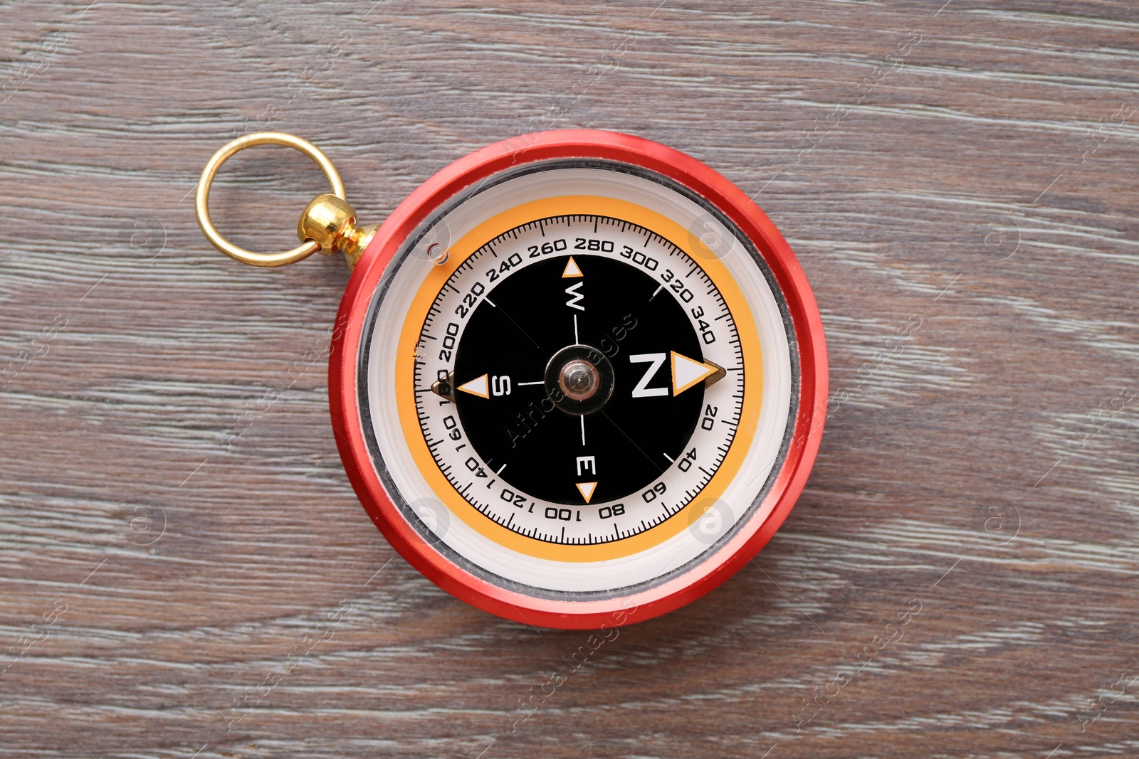 Photo of One compass on wooden table, top view